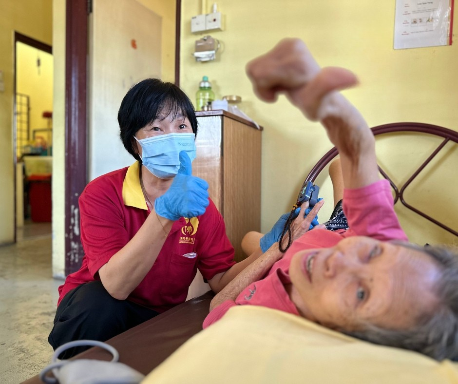 Amitabha caregiver with bedridden elderly resident